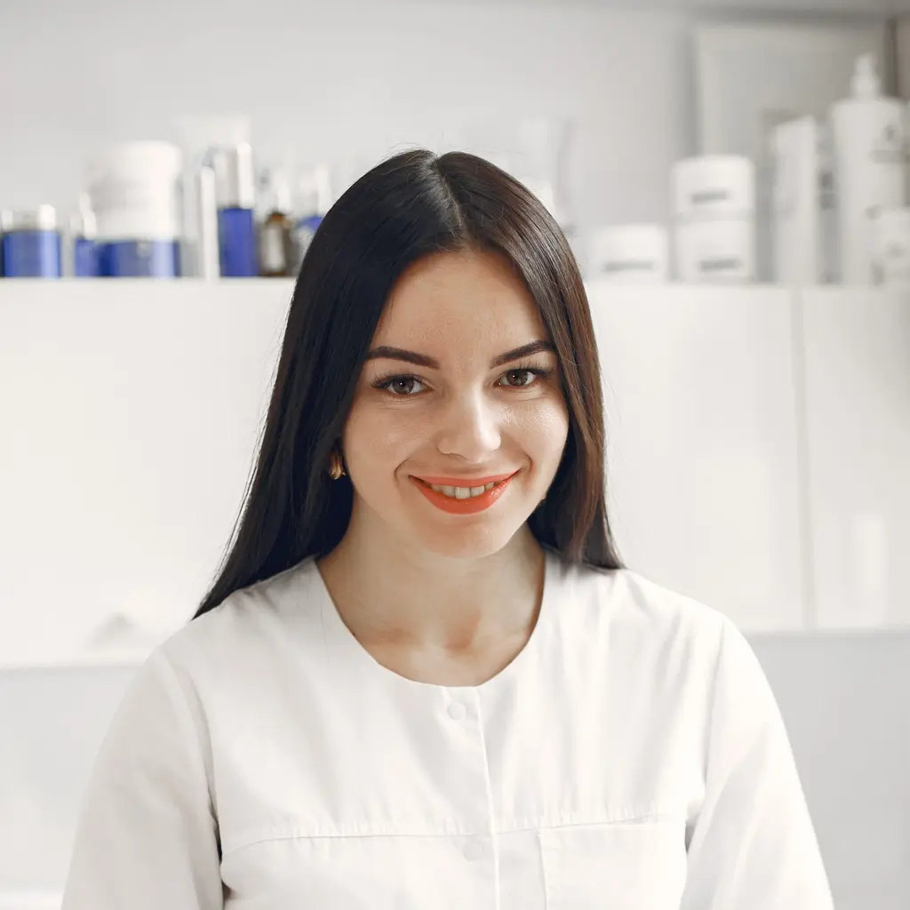 Ana, a esteticista da clínica, sorrindo, de jaleco branco.